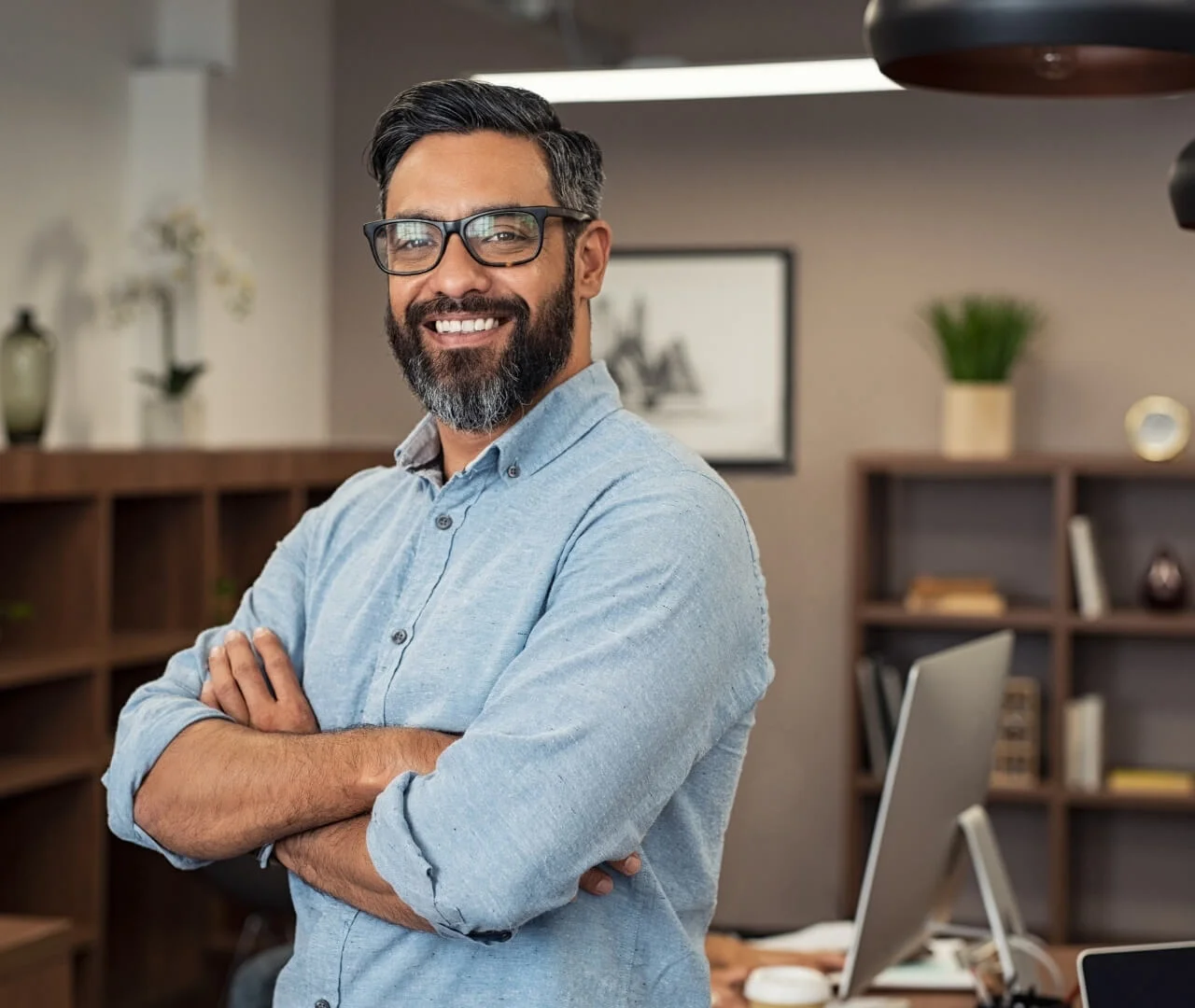 Confident man standing in modern office, smiling.